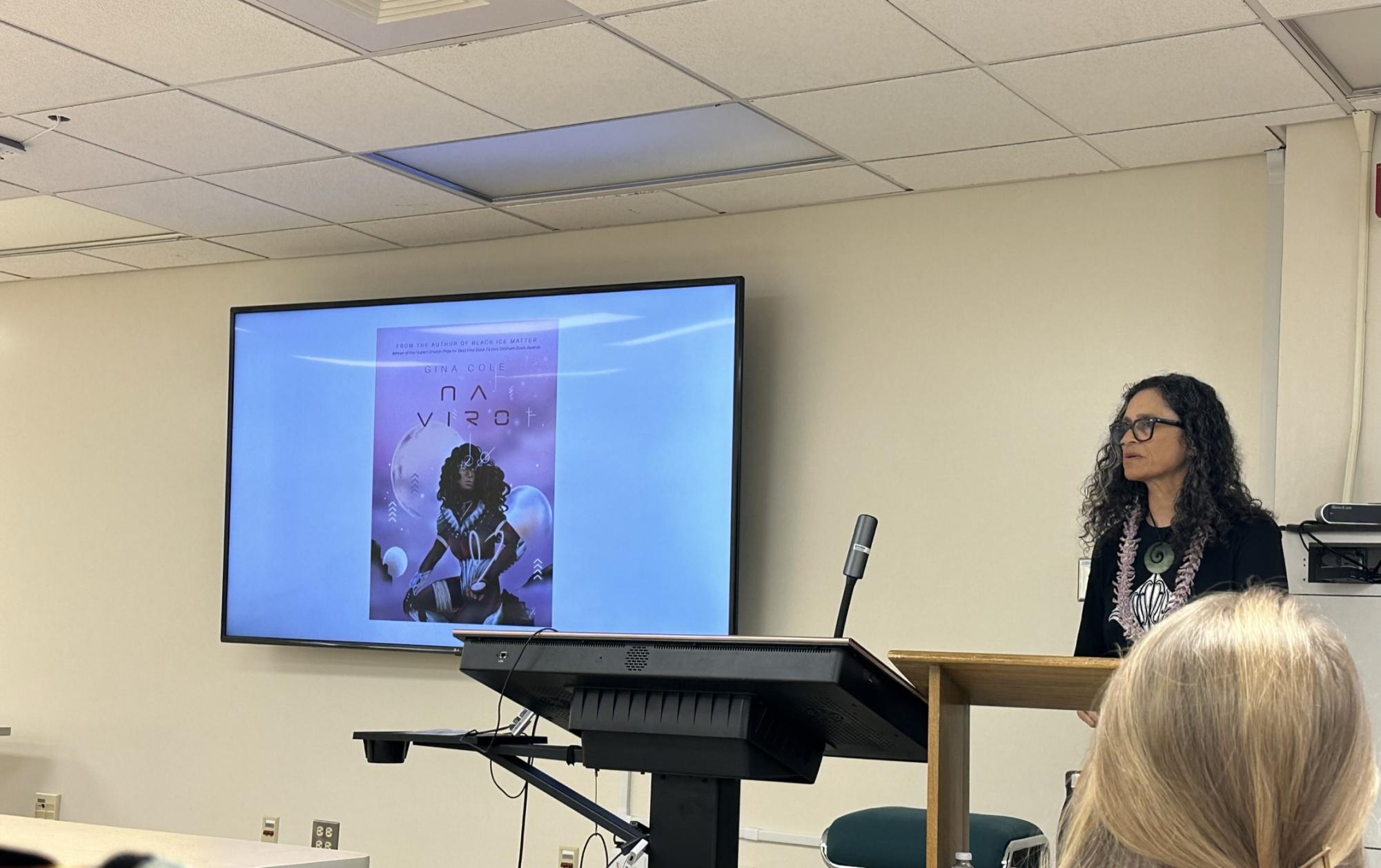 During a speech at UH, Gina Cole showcases her Pasifika Futurism novel titled Na Viro.