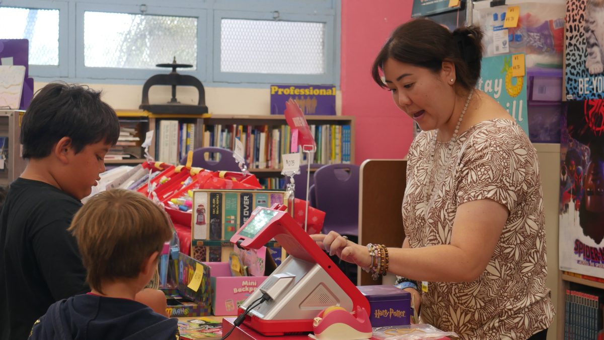 Shelley Lau, Aina Haina Elementary school librarian, selling books to students at the school book fair. 