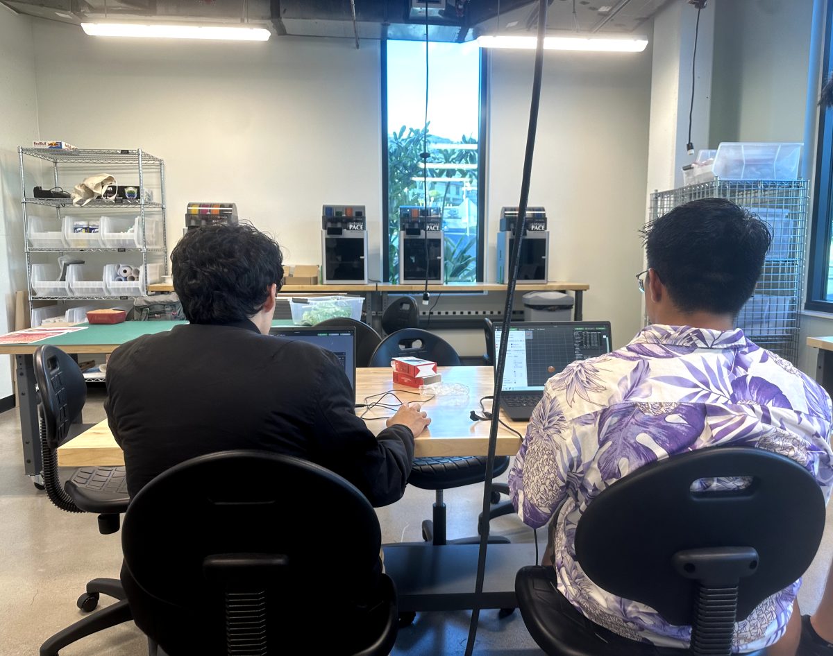 Workshop attendees in the Maker Space setting up an pumpkin ornament file to be 3D printed.