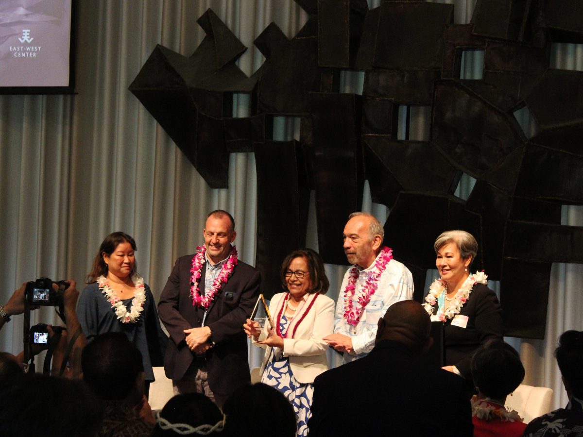 President Hilda Heine accepts the Women of Impact award, accompanied on stage by Governor Josh Green and First Lady Jaime Green, EWC Governor Chair John Waihe'e, and EWC President Suzy-Vares Lum.