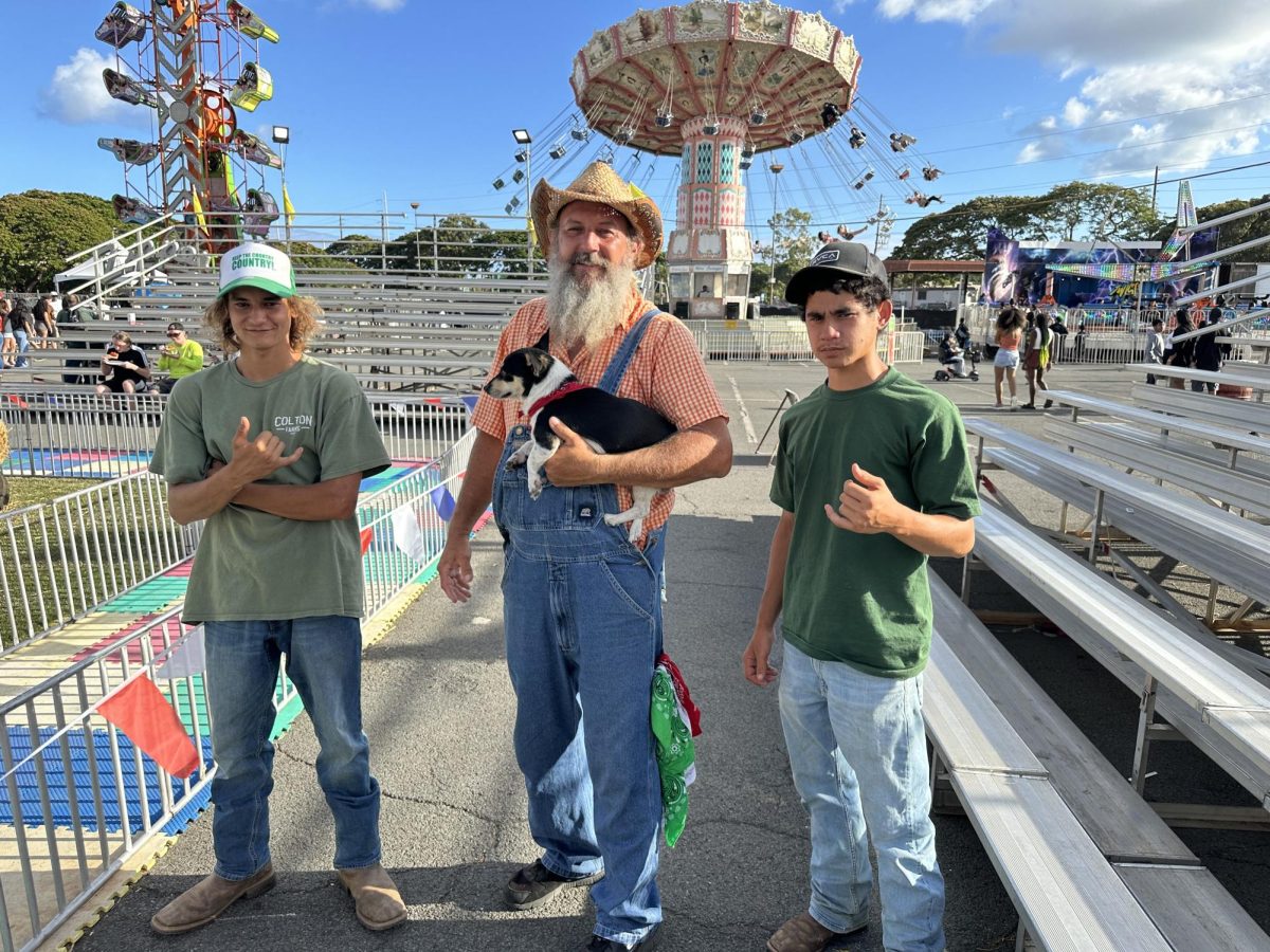 Nick Reeves, left, and his cousin Claude Colton, center, of Colton Farms host a petting zoo and share their farm culture at Hawai'i's 50th State Fair in early July.