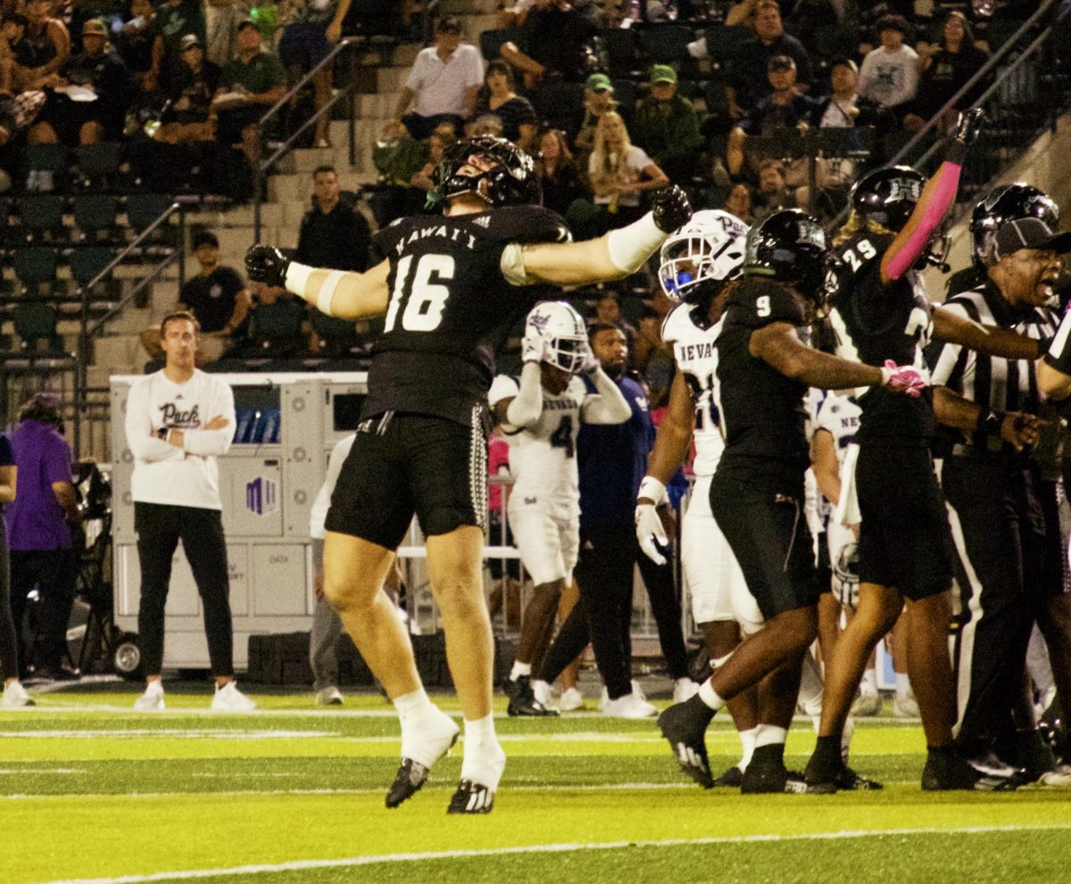 Rainbow Warrior #16: Logan Taylor (LB) screams and throws arms upward as he approaches the referee at the UHM/Nevada Football game. 