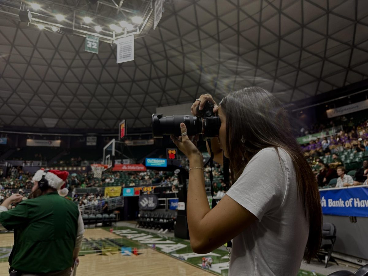 Sports Media photographer Lauren Sharkey shoots a UH Manoa men's basketball game.