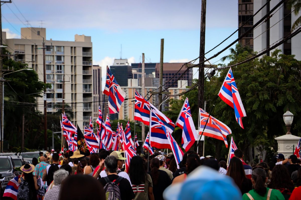 Native Hawaiians and allies waving Hae Hawaiʻi (Hawaiian Flag) together, marching to ʻIolani Palace.