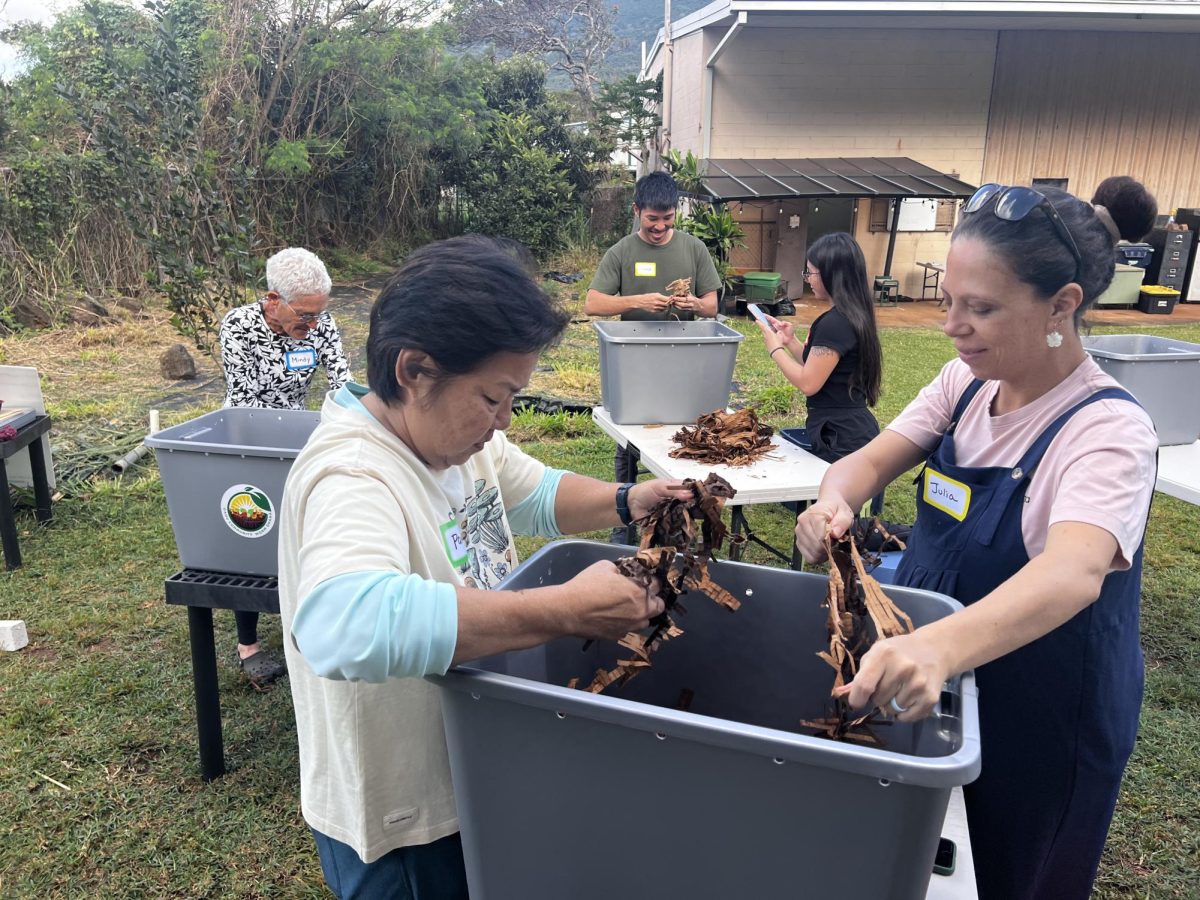 Volunteer Pam Kino helps workshop participant Julia Avila rip apart used cardboard to serve as bedding in her vermicompost bin. The cardboard will decompose and turn into worm food and eventually vermicast.